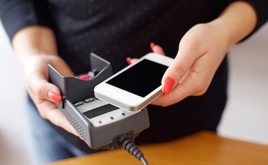 Woman paying with NFC technology on mobile phone