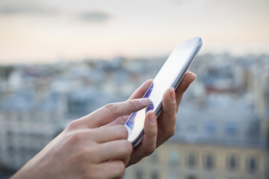 Woman using her mobile phone , city skyline background